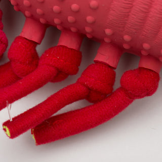 Close up image of lobster shaped durable plush dog toy legs:  showing one side of the lobsters four knotted legs and how they pass through the latex body.