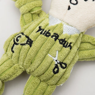 Close up of tiny plush corduroy dog toy groomer body showing detail of embroidered hairdryer and scissors.