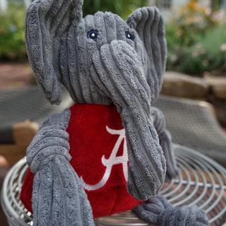 Close up of Alabama University Big Al grey elephant mascot durable plush corduroy dog toy with knotted limbs wearing red shirt and Alabama University logo on the front. Size large.