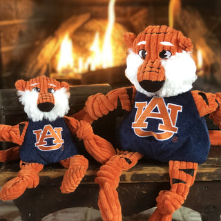 Set of two durable plush corduroy dog toys: Auburn University Aubie the tiger mascot with white fluffy face, knotted limbs wearing navy blue shirt and Auburn University logo on the front in small and large.