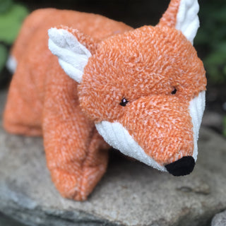 Front view of fox shaped durable Squooshie™ plush dog toy with orange body, white corduroy chin, tip of tail, and inner-ears, and black eyes and nose.