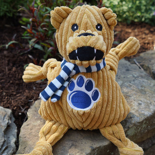 Penn State University, Nittany Lion, plush dog toy: has golden brown fur, blue and white striped scarf, university logo across the chest, and has knotted limbs.