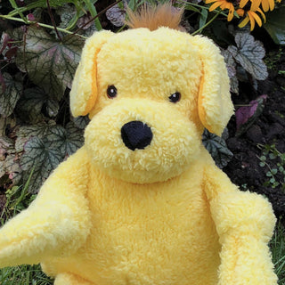 Dog shaped plush dog toy: has golden yellow fur, brown hair, brown eyes, white pupils, black nose, and has knotted limbs.