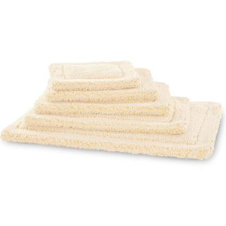 Stack of natural cream colored HuggleFleece® dog mats in sizes xs through xxl.
