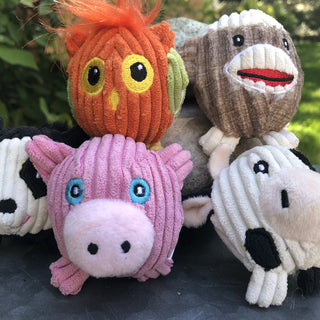 Set of five tiny plush corduroy ball dog toys: orange and lime green owl, brown and white sock monkey, black and white raccoon, pink pig, and black and white cow. Raccoon slightly out of frame to left.