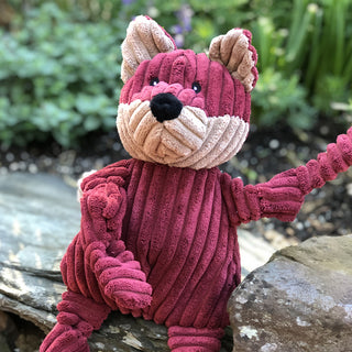 Burgundy fox with knotted limbs outside.